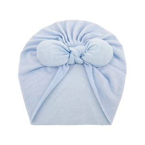 Detail of light blue baby turban hat with a large knot, soft knit fabric texture closeup