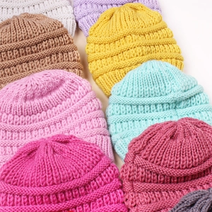 Collection of colorful knitted baby beanies in various candy colors for autumn and winter