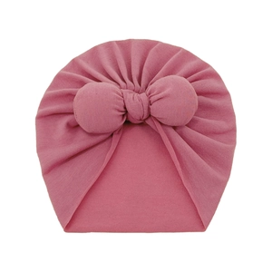 Detailed view of pink infant turban hat with a large soft decorative bow and rib knit texture