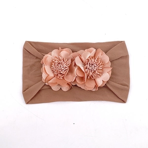 Detail of baby elastic headband with dual fabric flowers in brown soft knit fabric