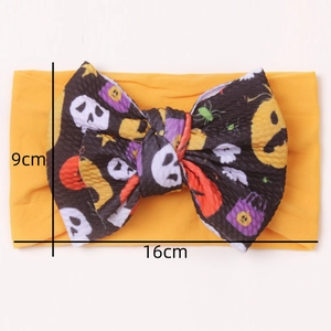 Detailed view of Halloween baby headband with pumpkin and skull bow showing 16x9cm size