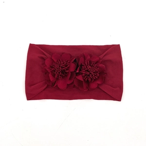 Detail view of burgundy elastic baby headband featuring two soft 3D fabric flowers