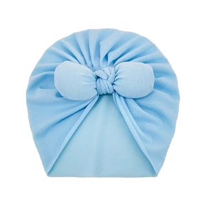 Close-up of soft light blue baby turban hat with large bow and pleated fabric detail