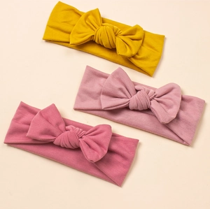 Three-piece set of ribbed knit baby headbands with large bows in yellow and pink shades