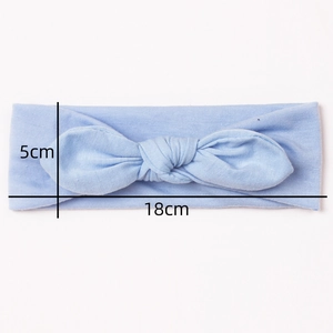 Détail d'un bandeau bébé bleu clair avec nœud papillon et dimensions 18 cm sur 5 cm