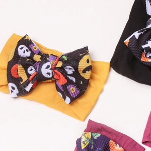 Macro shot of Halloween baby headband bows featuring skull and pumpkin patterns