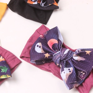 Detail of baby Halloween headbands featuring waffle texture bows with ghost and star prints