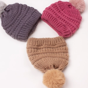 Three-color chunky knit baby beanies with large faux fur pom-poms on white background