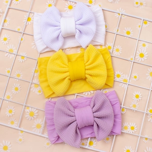 Detailaufnahme der Waffeltextur von Baby-Stirnbändern in Weiß, Gelb und Lila Farben