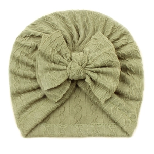 Detailed knit texture of bean green baby turban hat with a large decorative bow