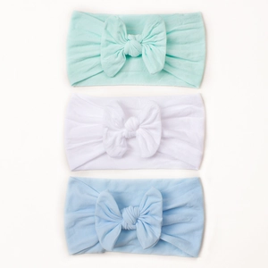 Detailansicht von drei elastischen Nylon-Baby-Stirnbändern in Minze, Weiß und hellem Blau