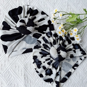 Detail of baby turban hats featuring stylish cow and leopard prints with spiral knot design