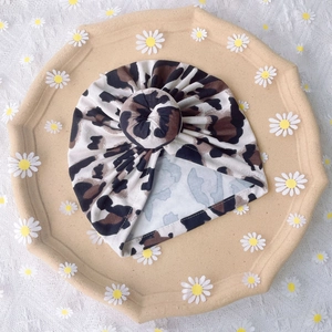 Detailed top view of leopard print baby turban hat with stylish top knot design