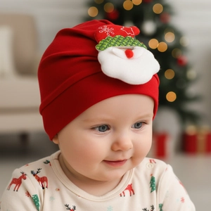 Close-up of red festive baby turban hat with a cute 3D Santa Claus applique for Christmas