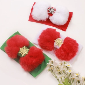 Dettaglio di fasce natalizie per neonati con pompon e fiocchi di neve in tre colori