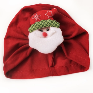Festive red baby Christmas hat featuring a plush Santa Claus ornament on white background