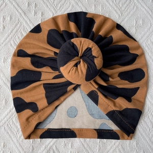 Detailed knit texture of a soft infant donut knot turban hat with leopard print pattern