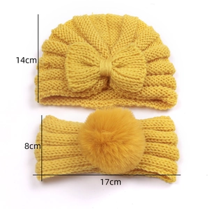 Detailed size view of yellow knit baby turban and matching headband with big bow and pom pom