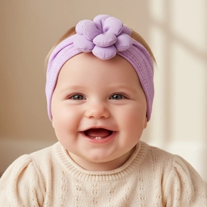 Détail du bandeau en nylon lavande pour bébé orné d'une grande fleur en tissu doux