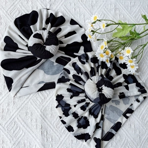 Soft cotton baby donut knot hats in black and white cow and grey leopard prints