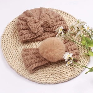 Detail view of khaki knit baby beanie with bow and faux fur pom-pom headband set