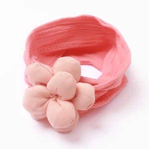 Détail d'un bandeau rose doux en nylon pour bébé avec une grande fleur 3D rembourrée
