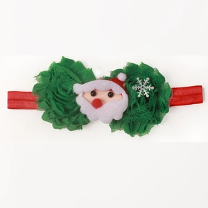 Detailed view of red elastic baby headband with green chiffon flowers and Santa felt charm