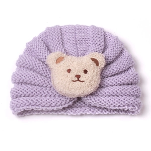 Detail of baby light purple ribbed knit hat with a soft off-white plush bear decoration