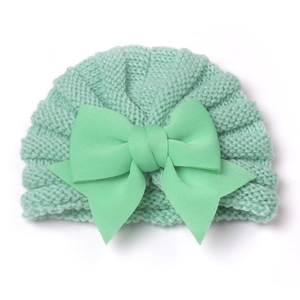 Détail du bonnet en tricot pour bébé vert menthe avec un grand nœud décoratif