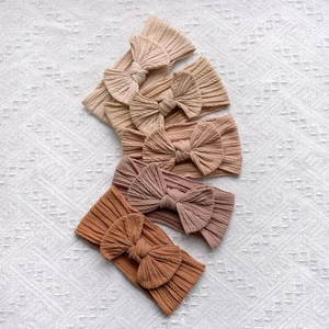 Détail de 5 bandeaux bébé élastiques en nylon souple avec nœuds géants aux tons terre