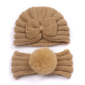 Detailed view of camel knit baby beanie with bow and matching pom-pom headband set