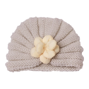 Detailaufnahme der Baby-Strickmütze mit großer 3D-Stoffblume in weichem Beige