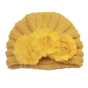 Detailed texture of yellow knit baby beanie featuring large 3D mesh flower decorations