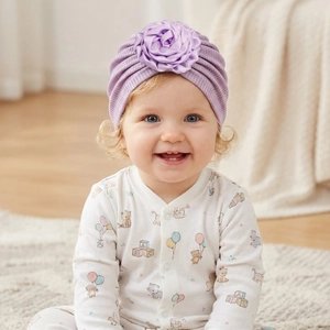 Detailed texture of purple ribbed baby turban hat with a large satin rose decoration