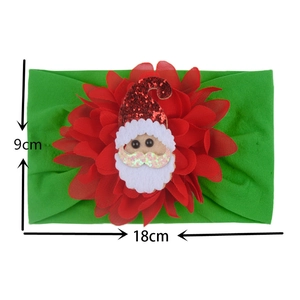Detail view of 18x9cm green elastic headband with red flower and Santa Claus motif