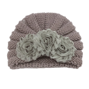Detailed close-up of knitted baby hat featuring three 3D fabric flowers and soft mesh