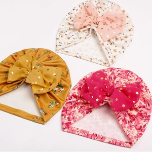 Détail de turbans pour bébé avec grands nœuds en tulle et tissu floral pour nourrissons