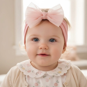Detail of pink nylon headband featuring a large double-layer mesh bow for baby girls