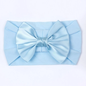 Détail du bandeau bébé en nylon bleu clair avec un grand nœud décoratif en satin