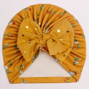 Détail du bonnet turban bébé jaune moutarde avec imprimé floral et nœud à pois dorés