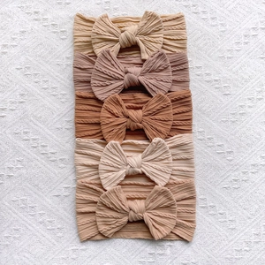 Détail de lot de 5 bandeaux bébé en tricot torsadé avec nœuds aux tons terre
