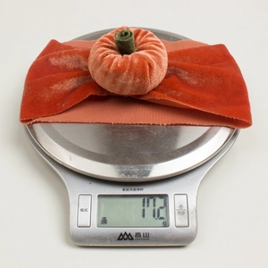 Kitchen scale showing the 17.2g weight of a velvet pumpkin headband for infants
