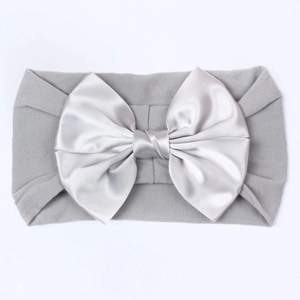 Gros plan d'un bandeau pour bébé en nylon gris clair avec un grand nœud en satin