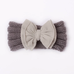 Detailansicht eines Baby-Strickstirnbands mit mehrlagiger Stoffschleife und grauer Webstruktur