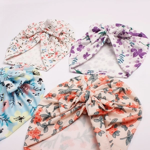 Detail view of four floral infant turbans with large bows and ribbed knit texture