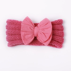 Detailansicht des leuchtend rosa gestrickten Babystirnbandes mit großer Stoffschleife