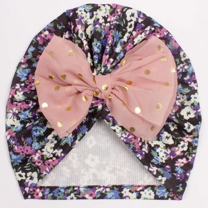 Détail du turban pour bébé avec imprimé floral et nœud en tulle rose à pois dorés brillants