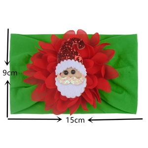 Detail view of green nylon baby headband with large red flower and Santa Claus sequin charm
