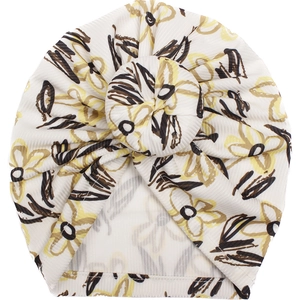 Detailansicht der weißen Baby-Turbanmütze mit Rippstruktur und gelbem Blumenmuster