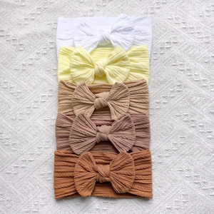 Détail du lot de 5 bandeaux bébé avec nœuds en tricot texturé aux tons naturels